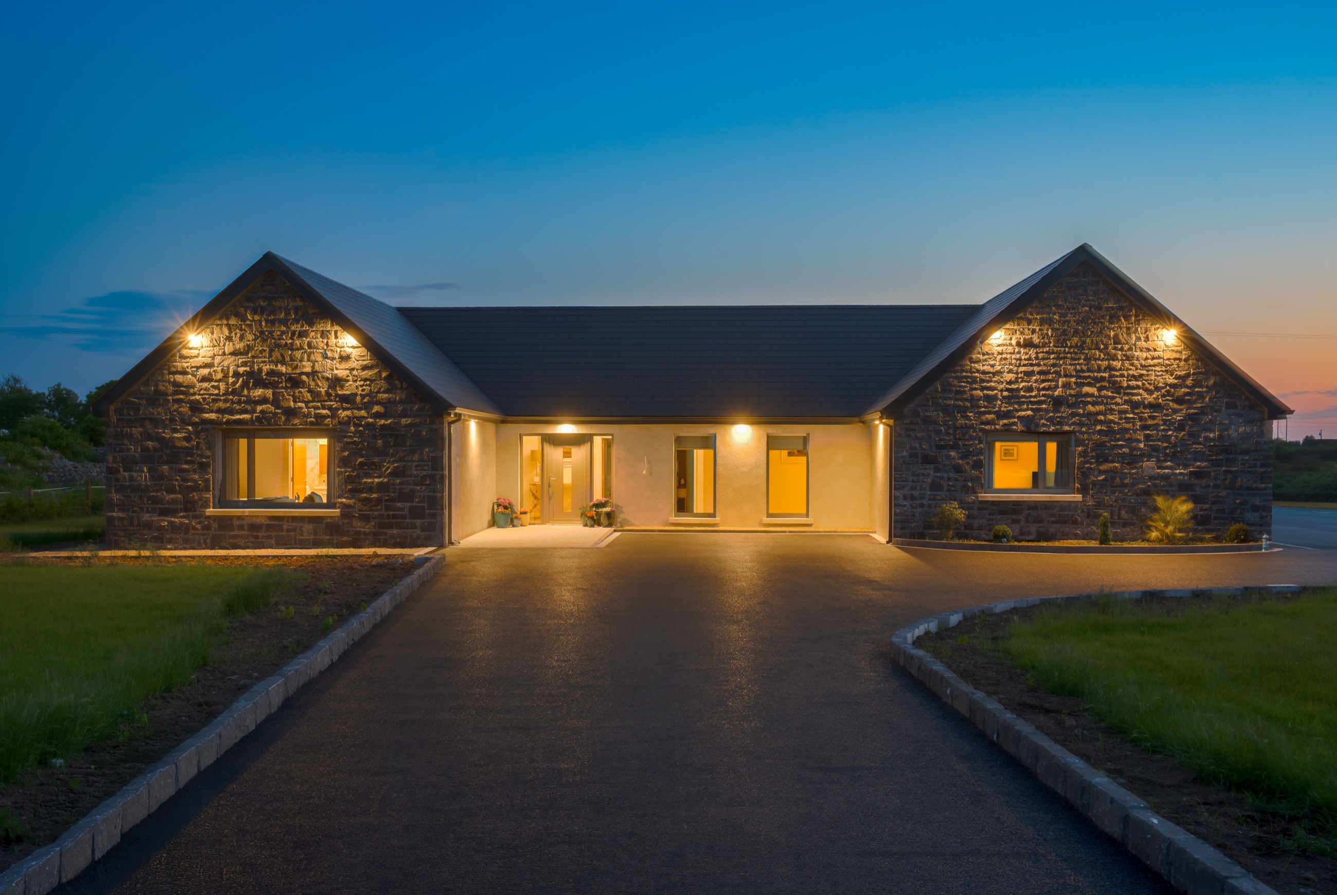 Skylark Lodge at twilight — a stone-clad lodge glowing warmly against a blue dusk sky